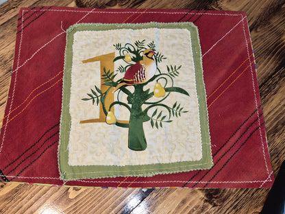 Decorative fabric square with a bird and tree design on a red background