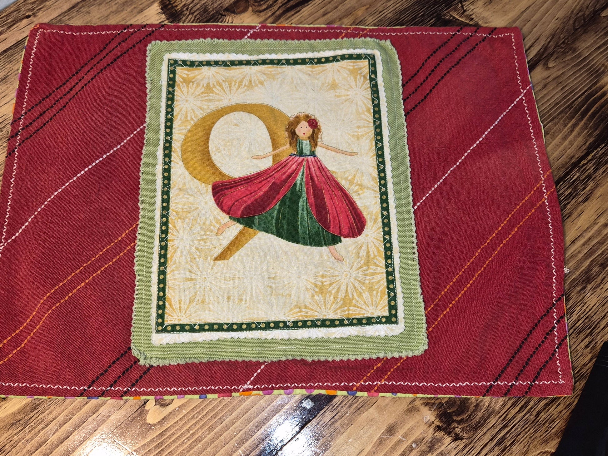 Decorative placemat with a design of a dancer in a red dress on a wooden surface.
